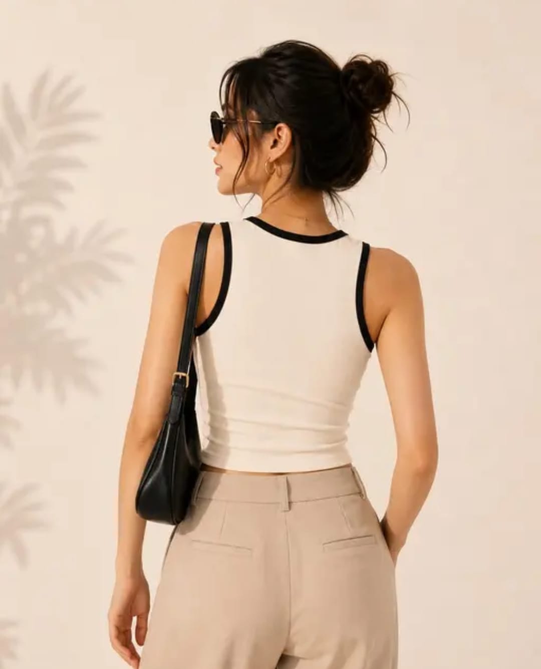cream crop top 3 Woman wearing a cream sleeveless crop tank top with black contrast trim