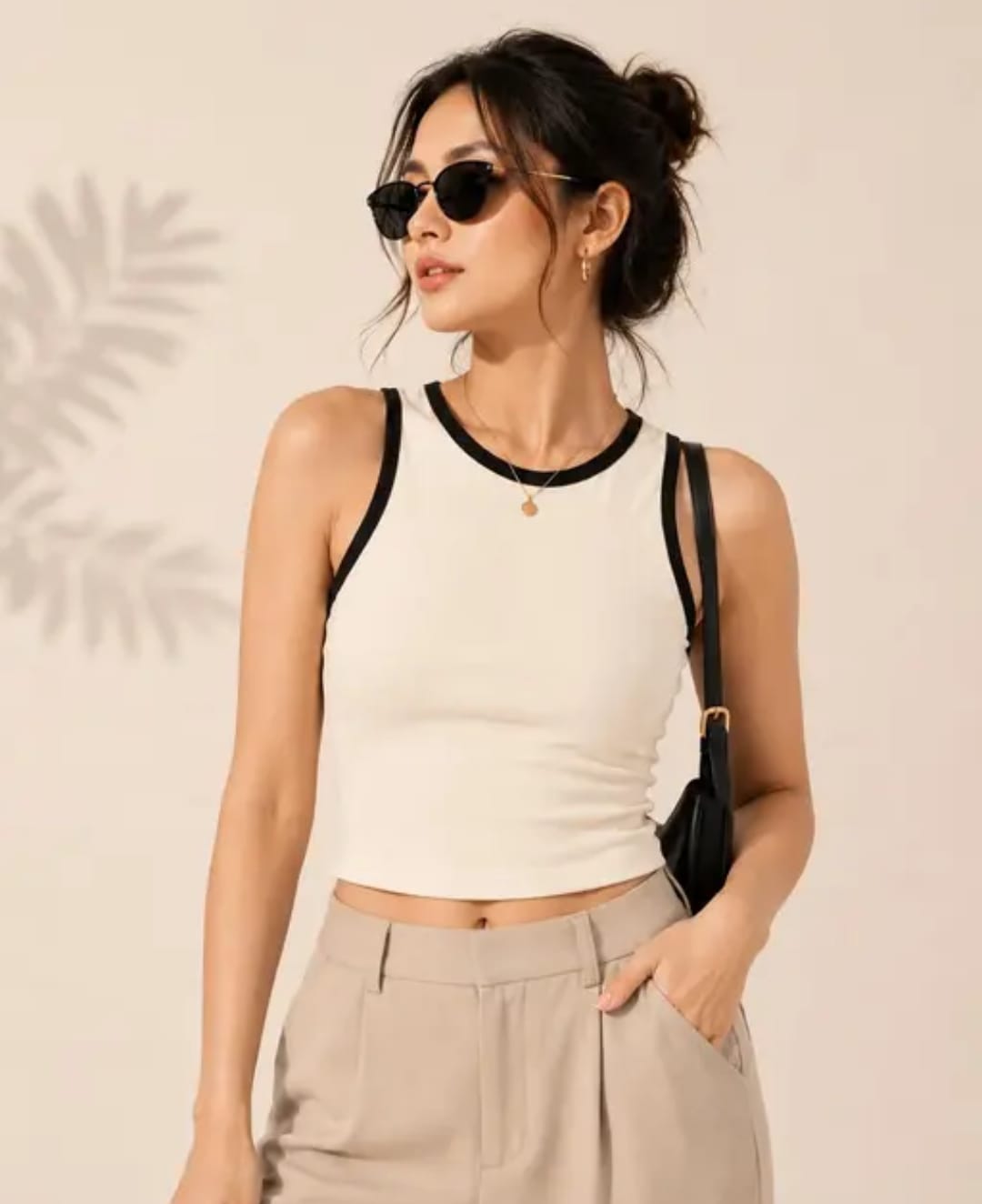 cream crop top Woman wearing a cream sleeveless crop tank top with black contrast trim