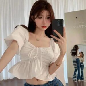 Woman wearing a white puff sleeve peplum crop top with a square neckline
