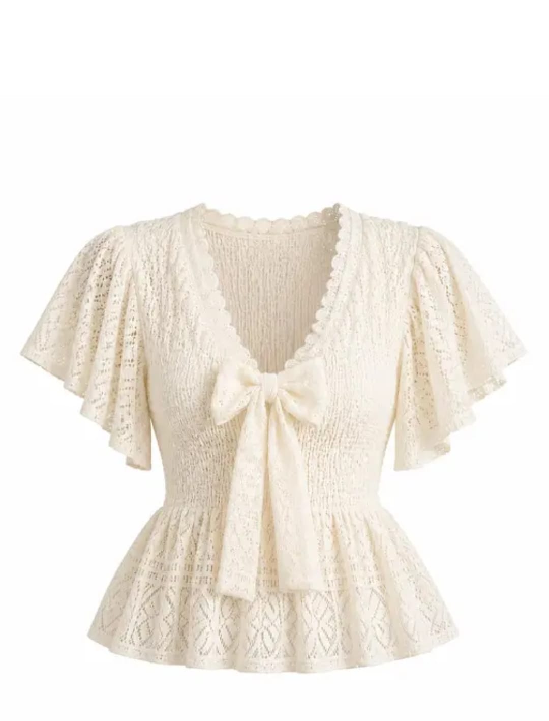 Woman wearing an ivory smocked peplum top with flutter sleeves, a square neckline, and a lace hem