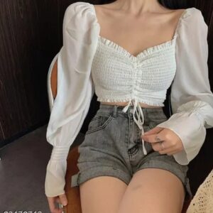 Woman wearing a white smocked sweetheart crop top with long puff sleeves and an adjustable front tie