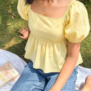 Woman wearing a sunny yellow puff sleeve peplum top